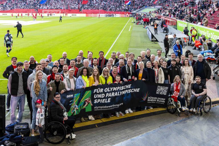 Gruppenbild im Fortuna-Stadion mit einem Banner, auf dem "Ja zu Olympia" steht